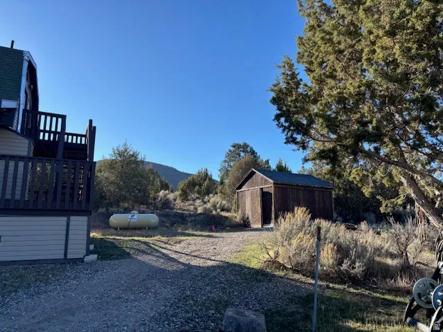 View of yard with a storage shed and a deck with mountain view