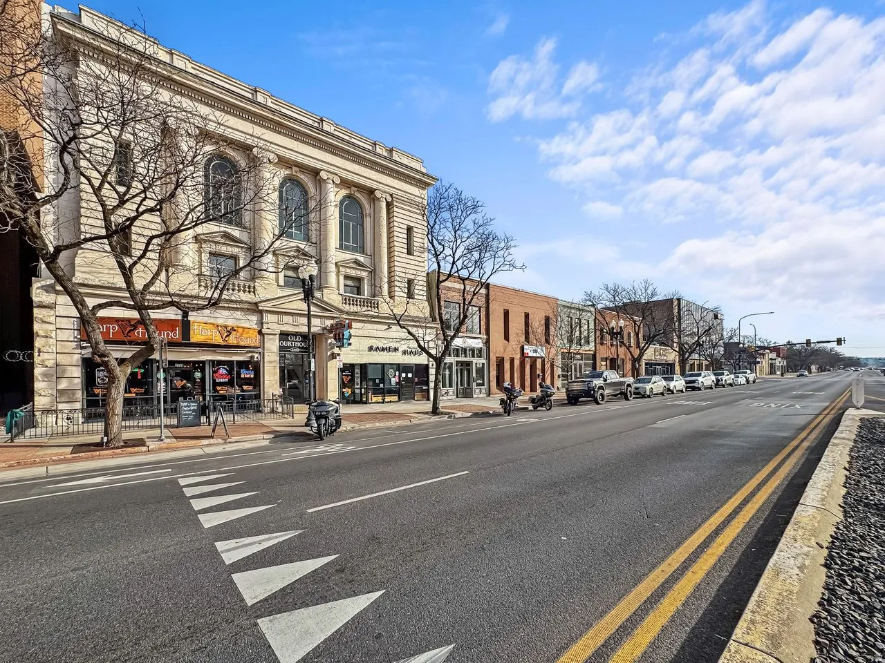 View of asphalt street with street lights, curbs, and sidewalks