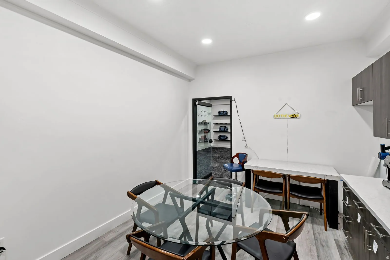 Office with light wood-type flooring and recessed lighting