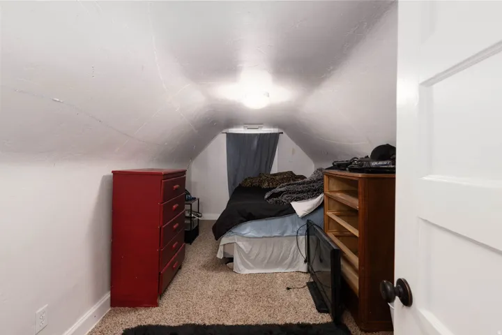 Bedroom with light colored carpet and baseboards