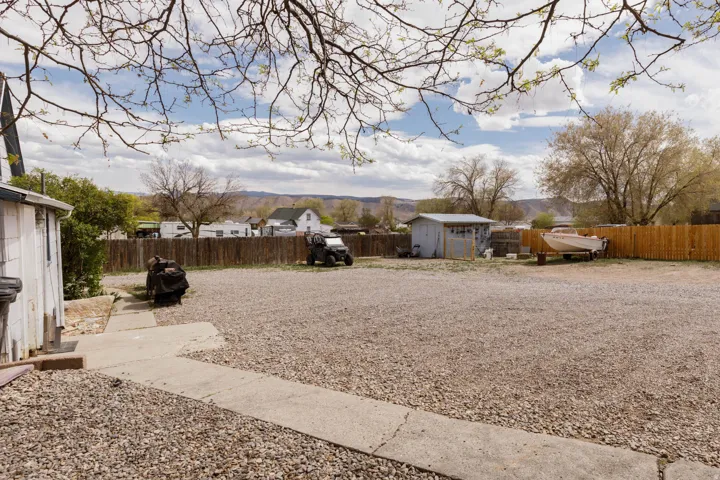 Fenced backyard with a storage shed and a residential view