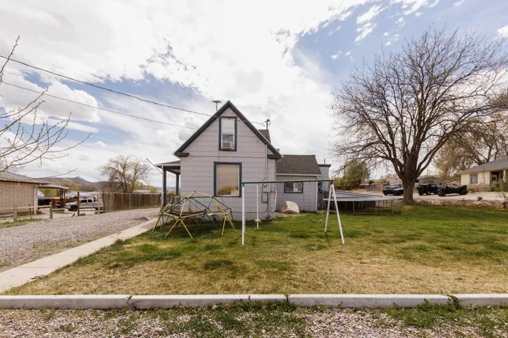 View of front of house featuring a playground and a shingled roof