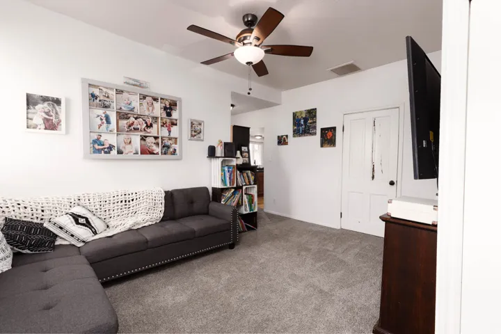 Living area with carpet floors and a ceiling fan