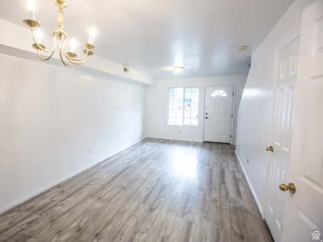 Entryway with wood finished floors and hanging lights