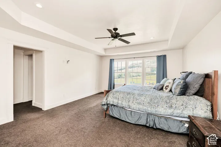 Spacious room with plush carpeting and a tray ceiling