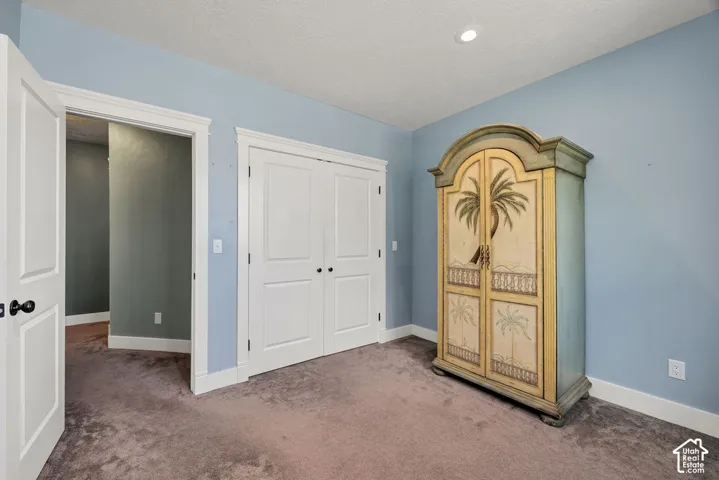 Blue-painted room featuring light gray carpeting, white baseboards, and white door frames