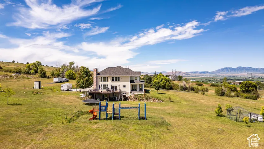 Multi-level residence featuring a rear deck with staircase access to the expansive yard