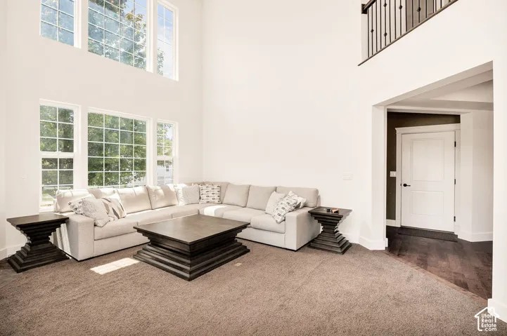Vaulted great room featuring tall windows, abundant natural light, and a second-story overlook with an iron balustrade