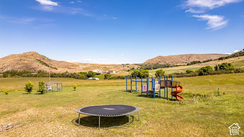 Expansive open grounds featuring distant mountain ranges and a clear blue sky