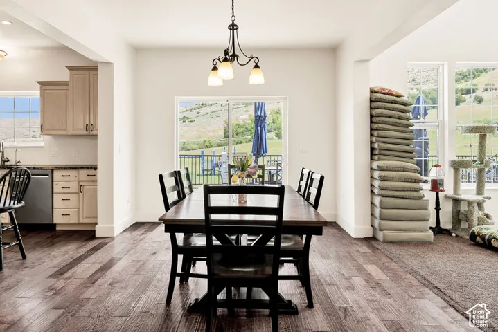 Dining area featuring a dark wood-finish table and chairs, illuminated by an overhead chandelier