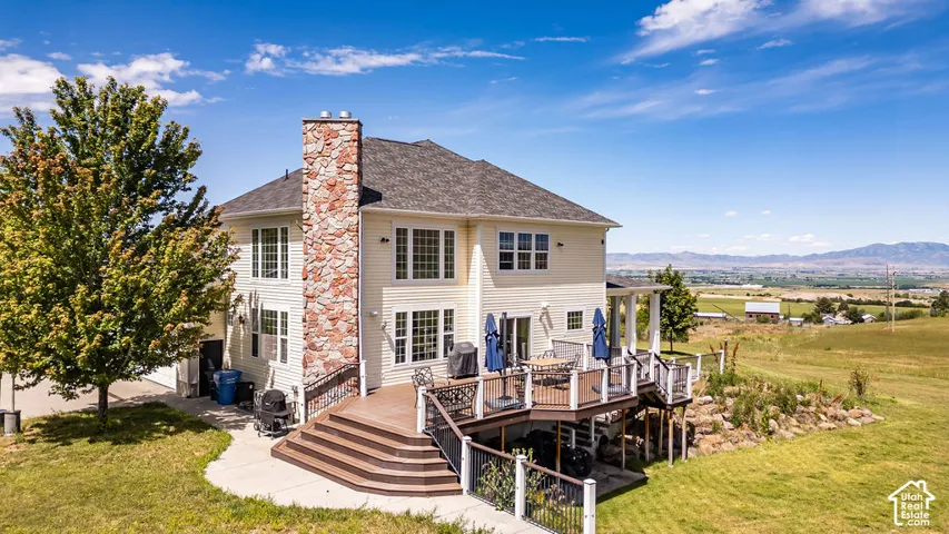 Rear exterior featuring a multi-tiered deck with dark wood-finish flooring and white railings