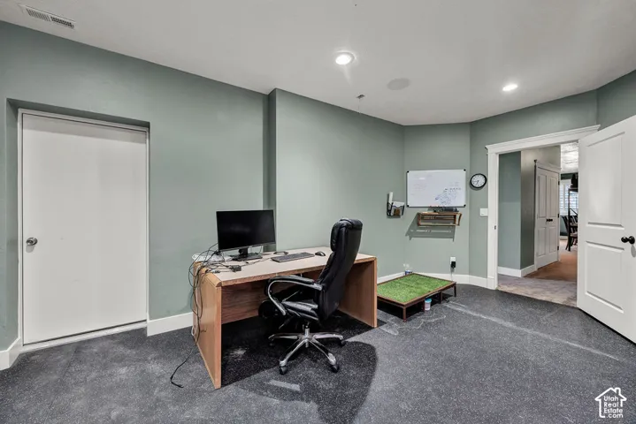 Flexible room featuring light green walls and dark carpet flooring