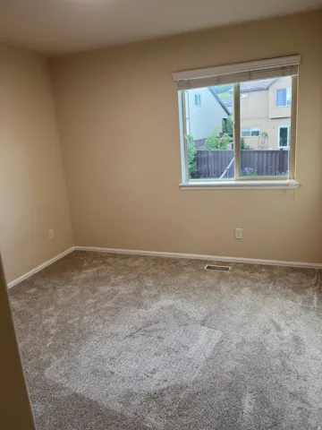 Carpeted empty room featuring baseboards