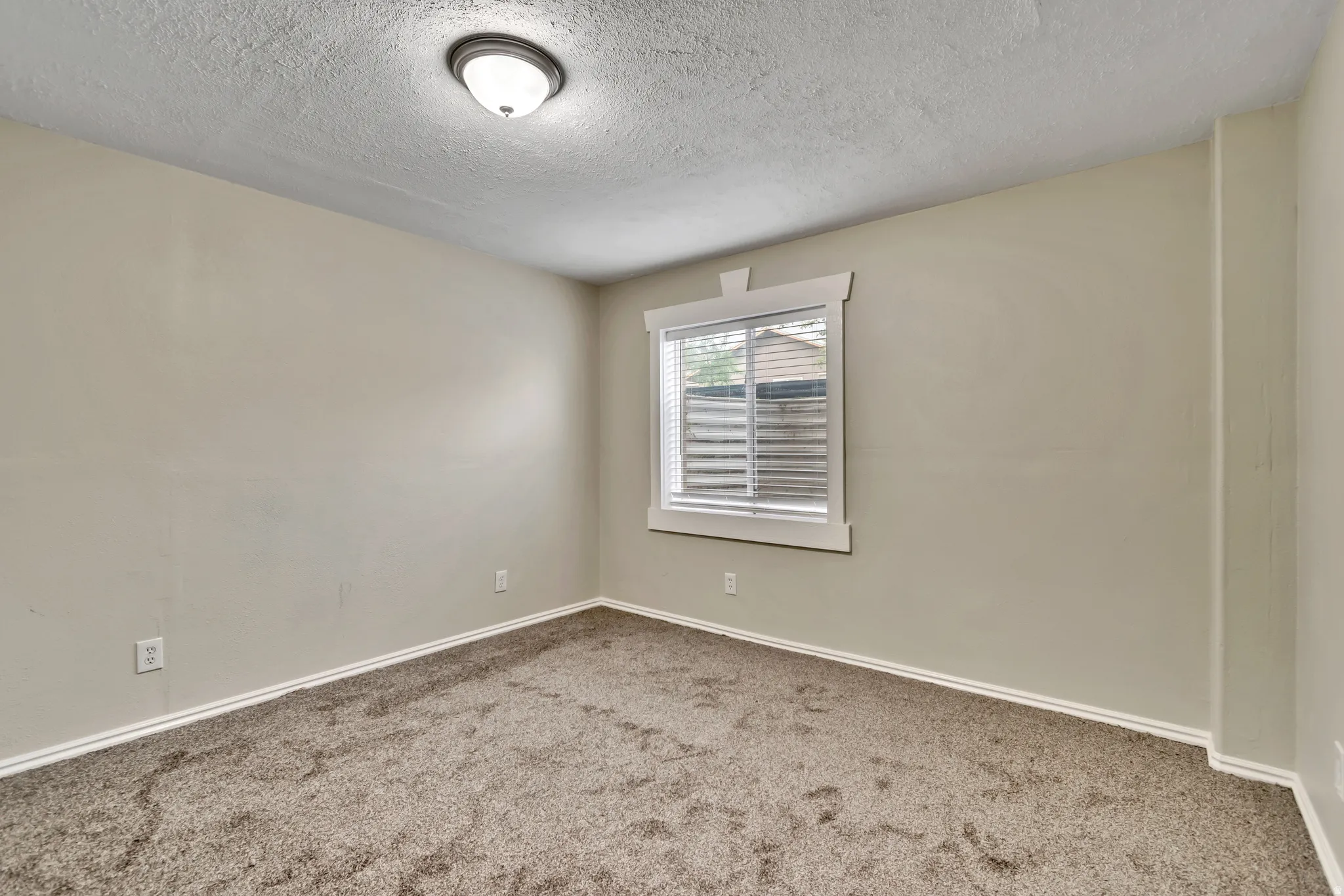 Unfurnished room with a textured ceiling and carpet
