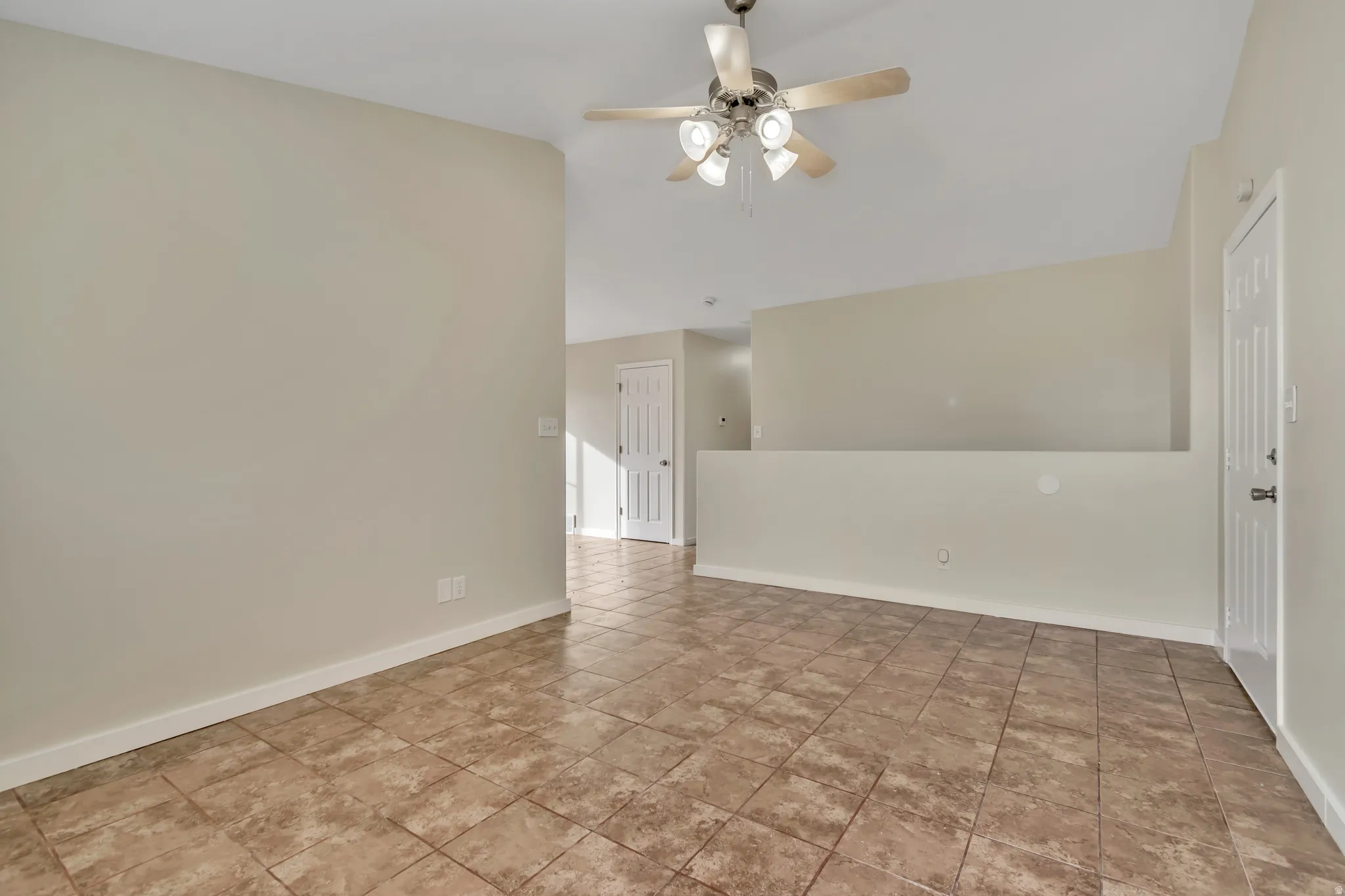 Spare room featuring a ceiling fan and baseboards