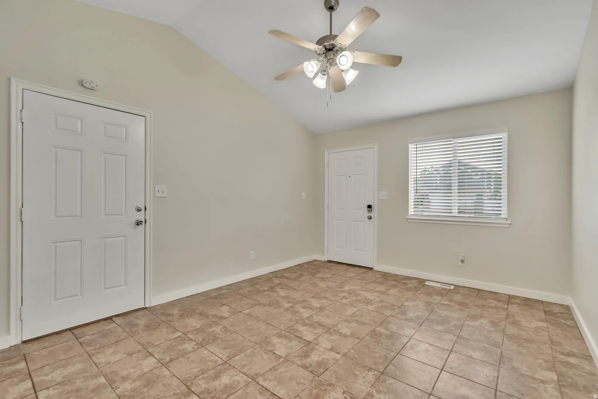 Entryway with a ceiling fan and lofted ceiling
