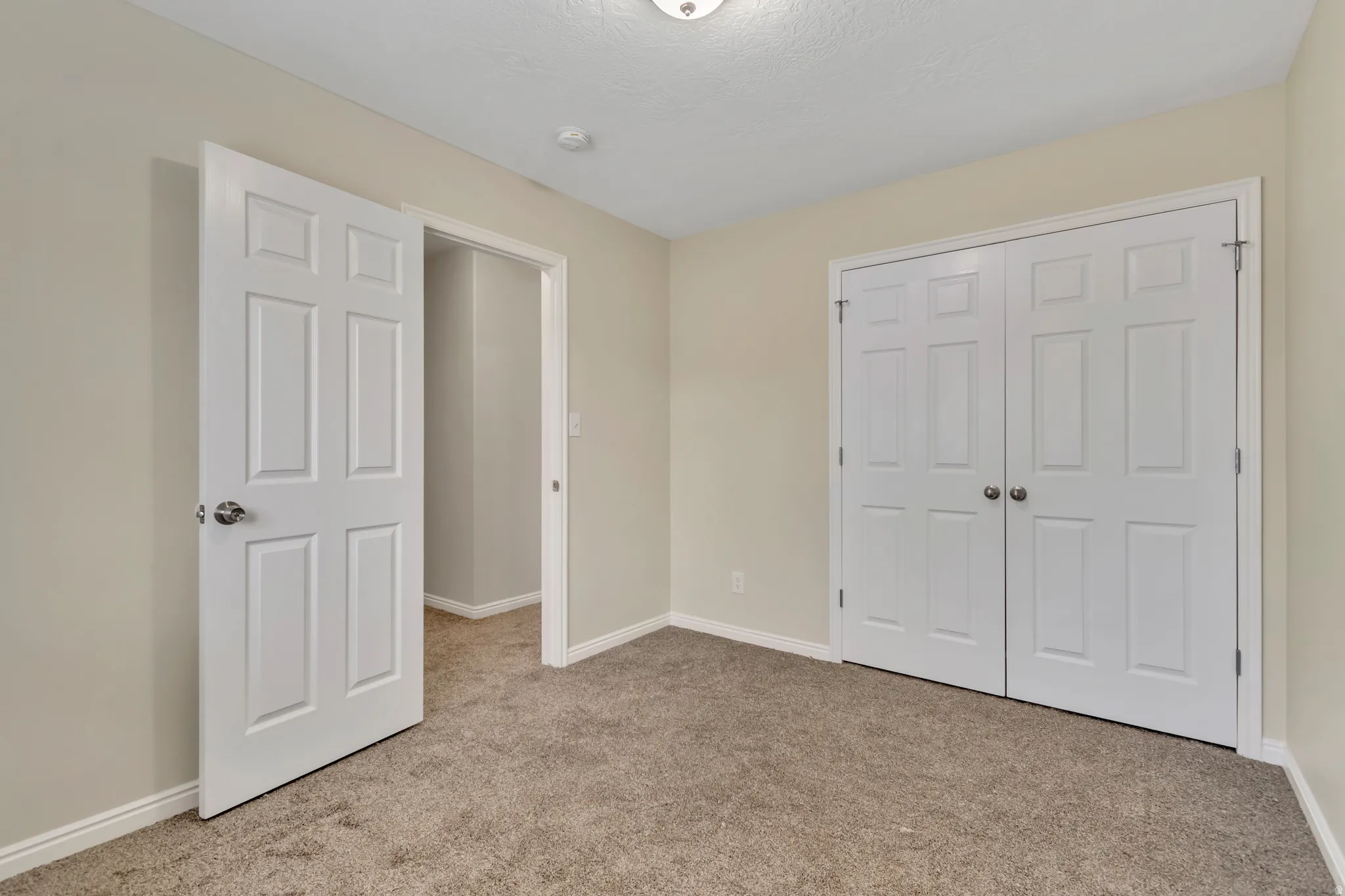 Unfurnished bedroom featuring light carpet and a closet