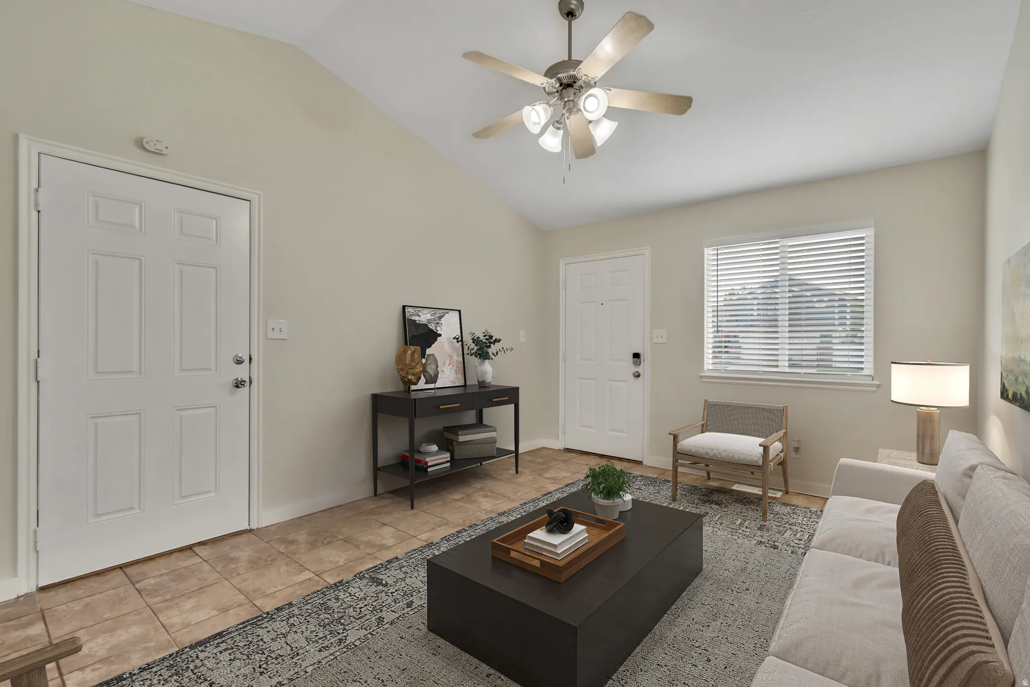 Living room with vaulted ceiling, a ceiling fan, and tile patterned flooring