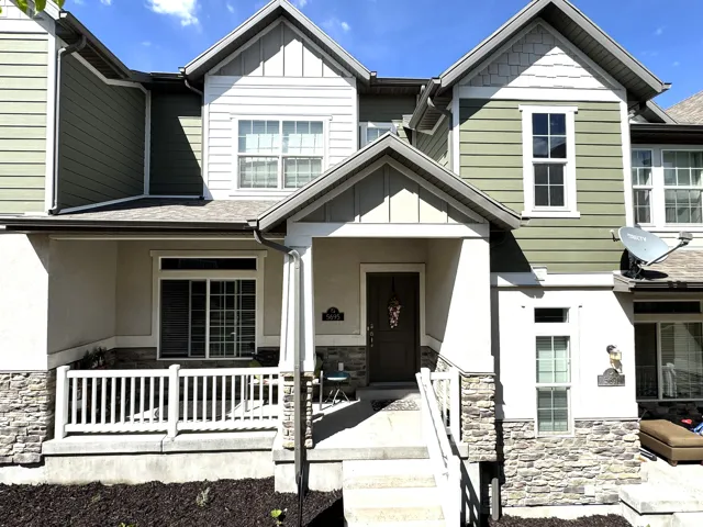 Craftsman-style home featuring stone siding, covered porch, board and batten siding, and roof with shingles