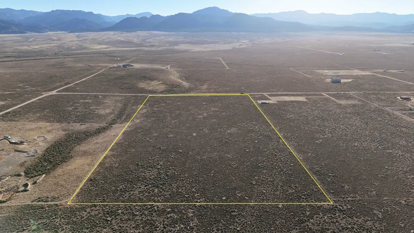 Overview of rural landscape with a mountain backdrop and property parcel outlined