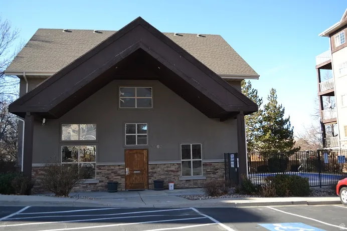 View of building exterior featuring uncovered parking