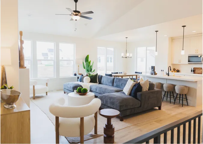 Open-concept living area with wood-finish flooring, vaulted ceilings, and large windows