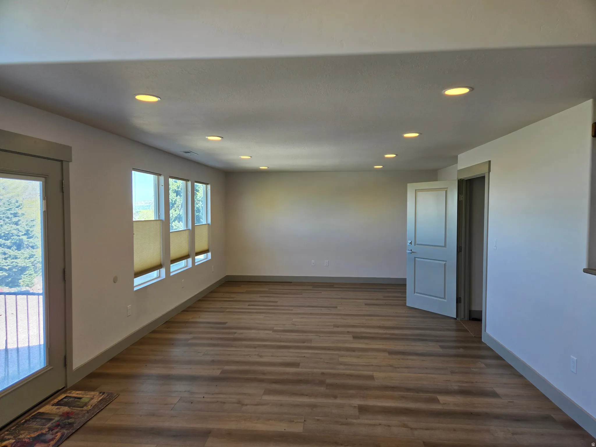 Spare room featuring recessed lighting and dark wood-style floors