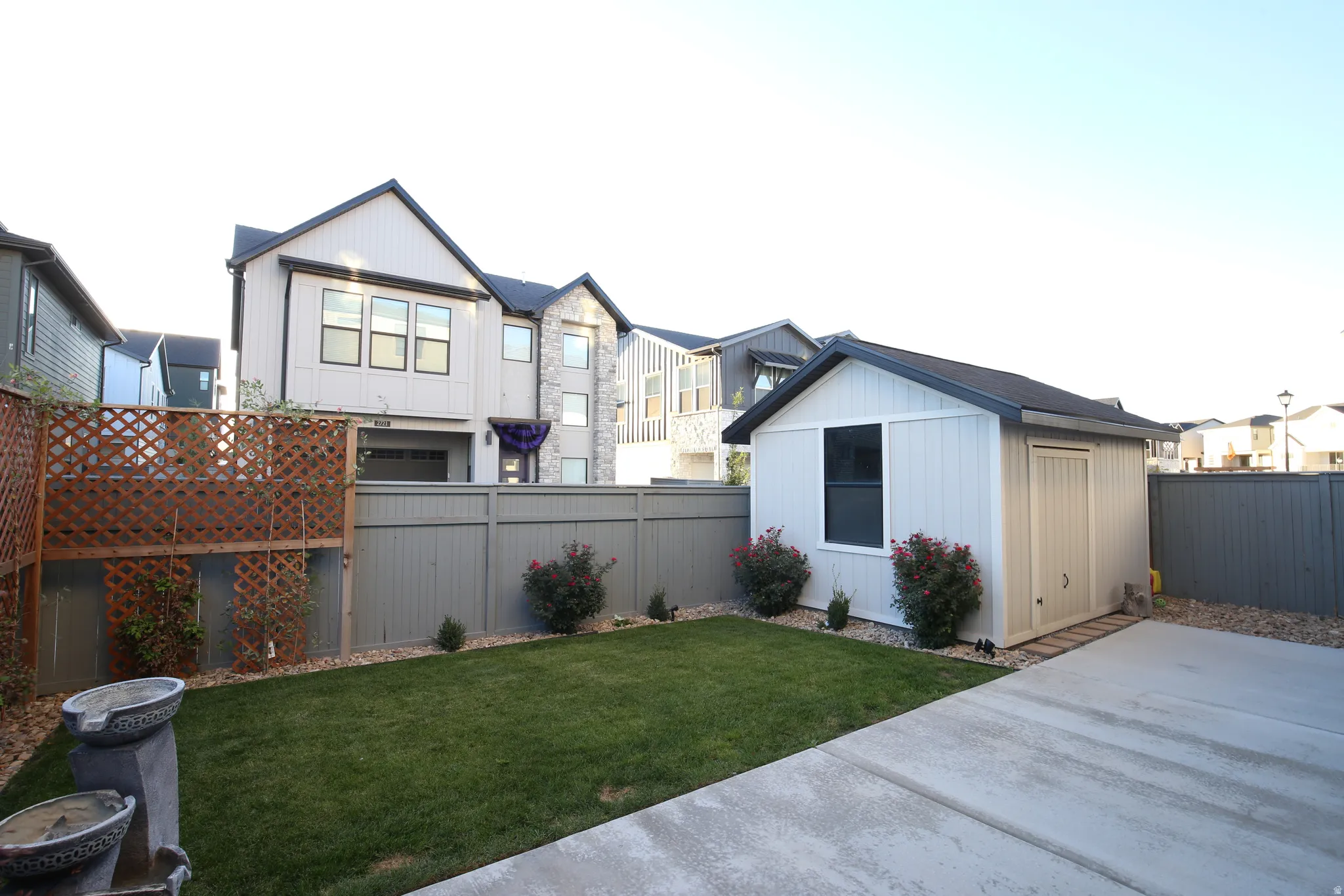Fenced backyard featuring an outbuilding and a residential view