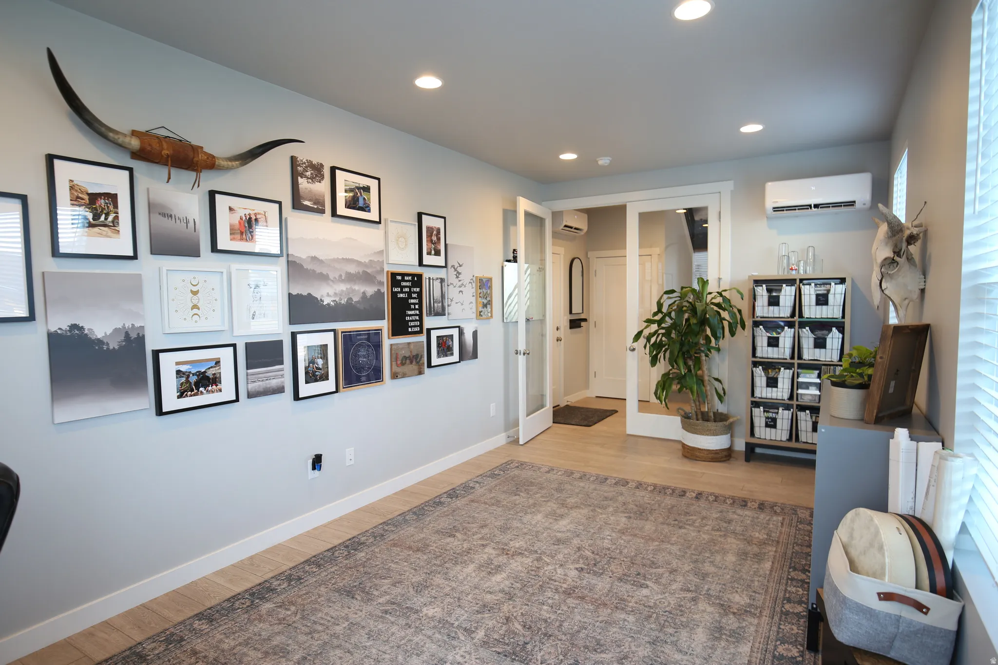 Living area with light wood finished floors and recessed lighting