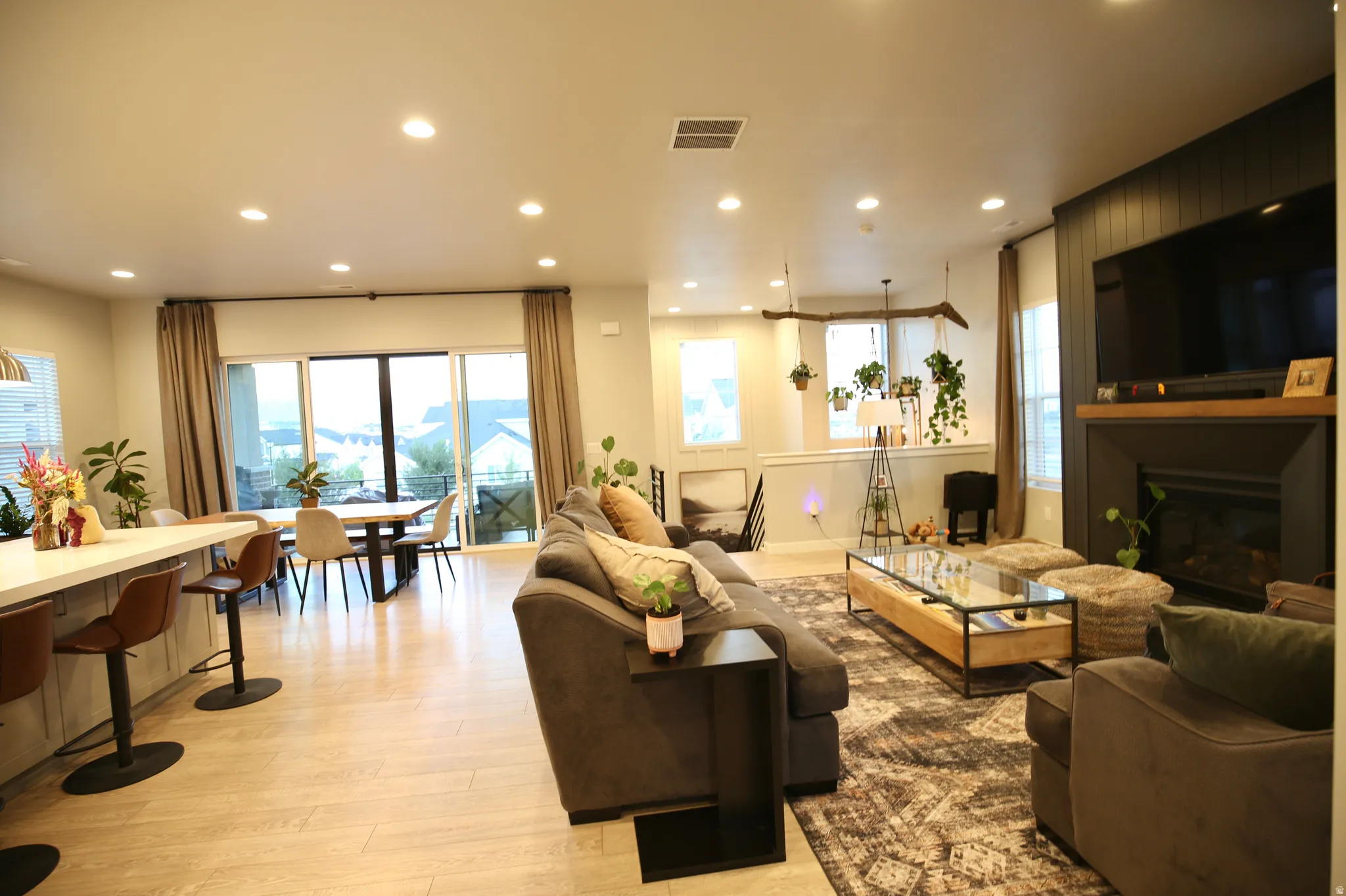 Living area featuring light wood-style floors, a fireplace, recessed lighting, and healthy amount of natural light