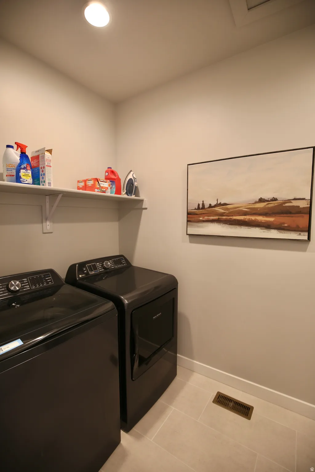 Laundry room featuring washing machine and dryer and light tile patterned flooring