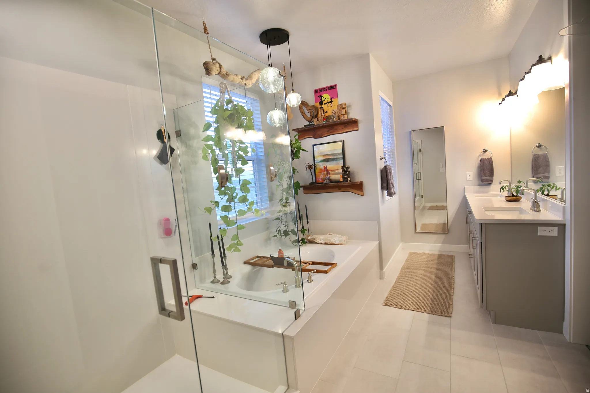 Full bath with a bath, a stall shower, vanity, and plenty of natural light