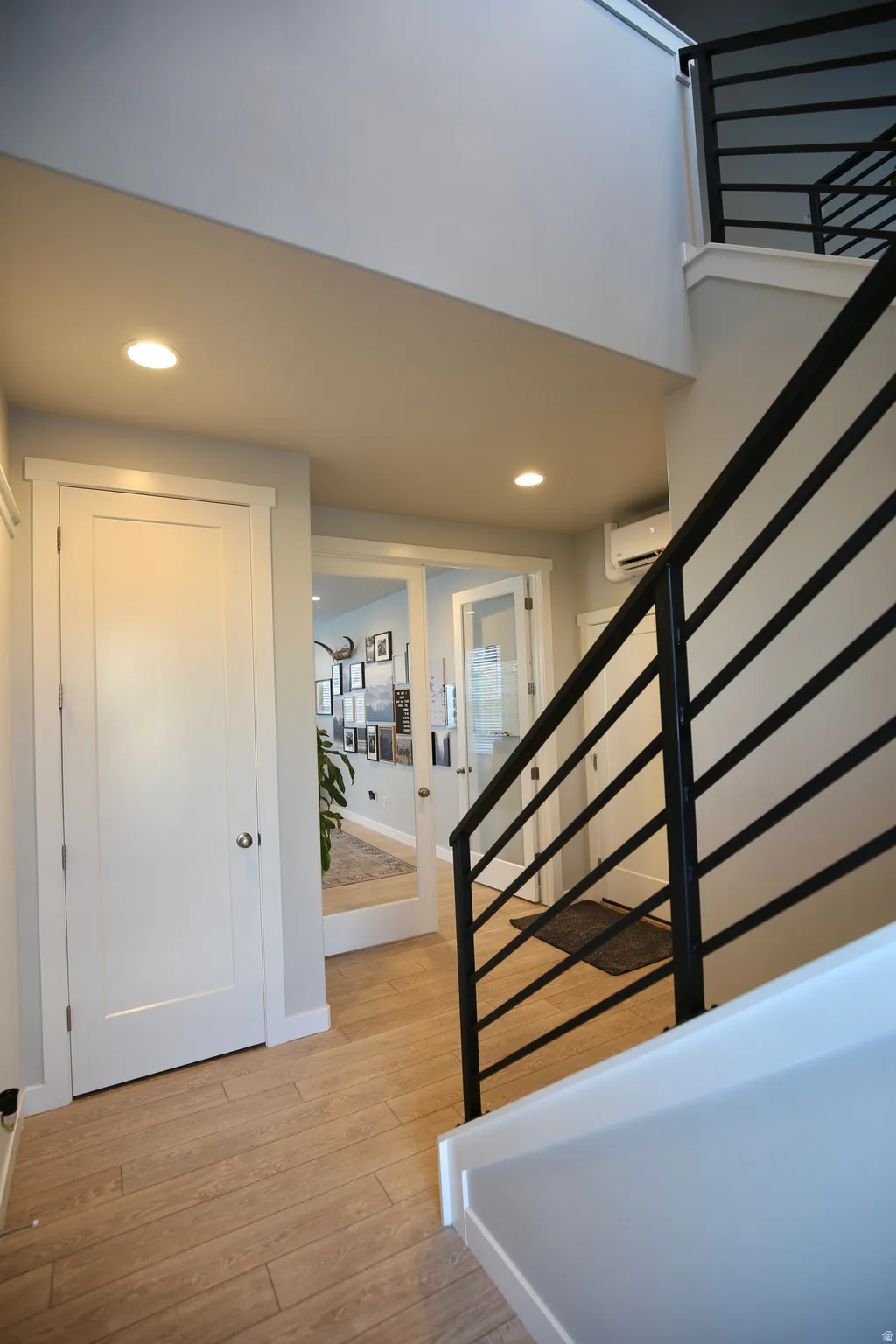 Stairway with recessed lighting and wood finished floors