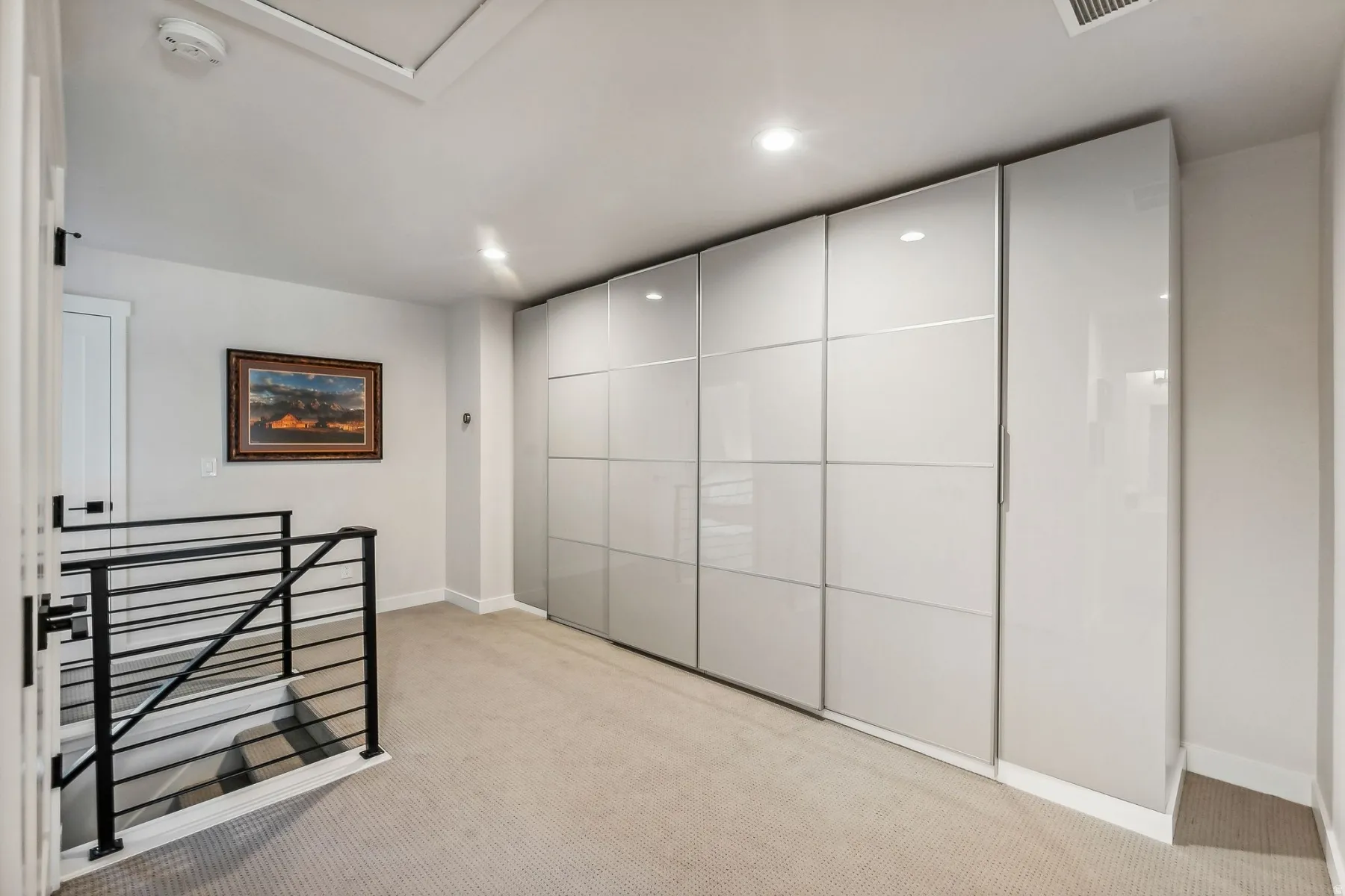 Unfurnished bedroom with light carpet and recessed lighting
