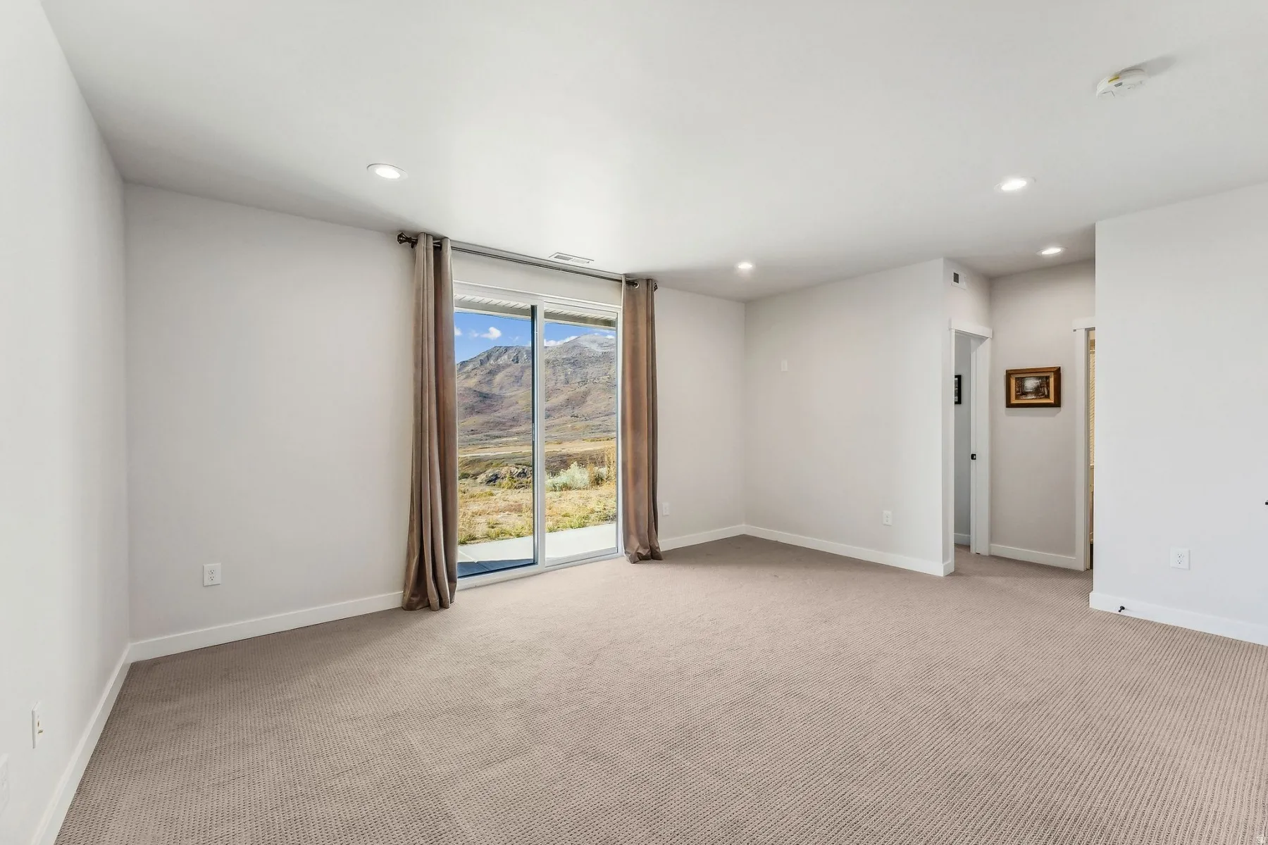 Spare room featuring a mountain view, light carpet, and recessed lighting