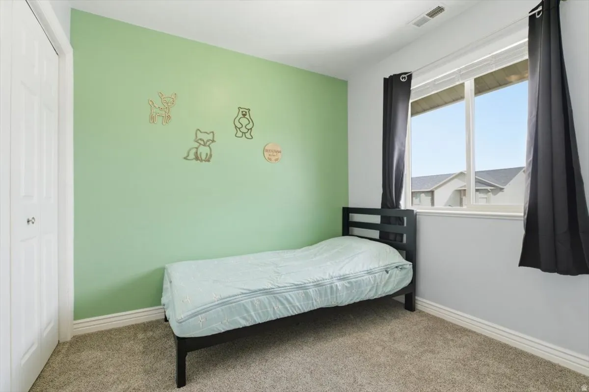 Carpeted bedroom with baseboards and a closet