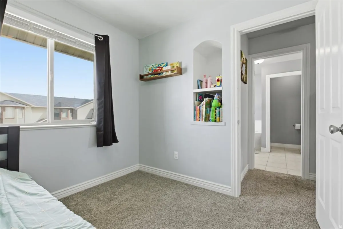 Bedroom with baseboards and light carpet