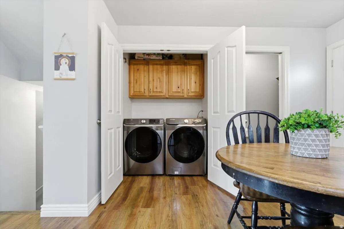 Laundry room featuring light wood-style flooring and washing machine and dryer