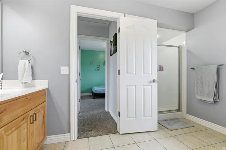 Bathroom with vanity, a stall shower, ensuite bath, and light tile patterned floors