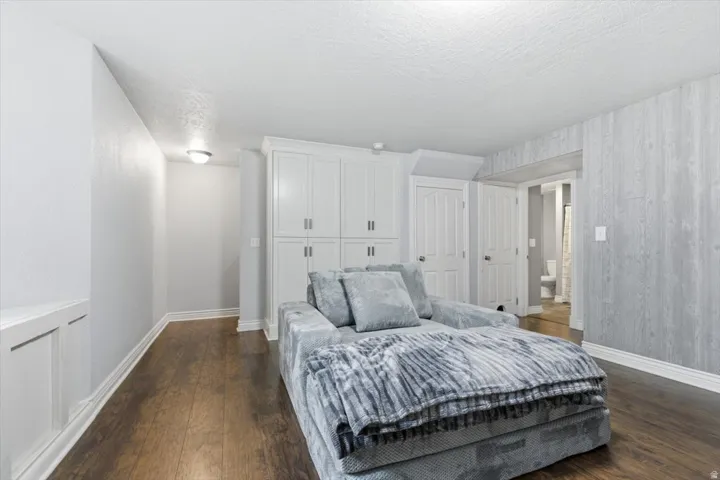 Bedroom featuring dark wood-style flooring, a textured ceiling, and a closet