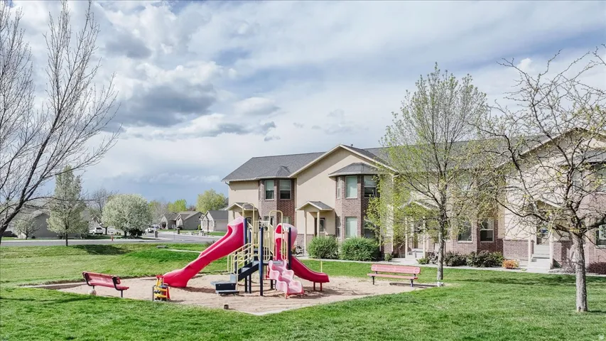Community play area featuring a lawn and a residential view