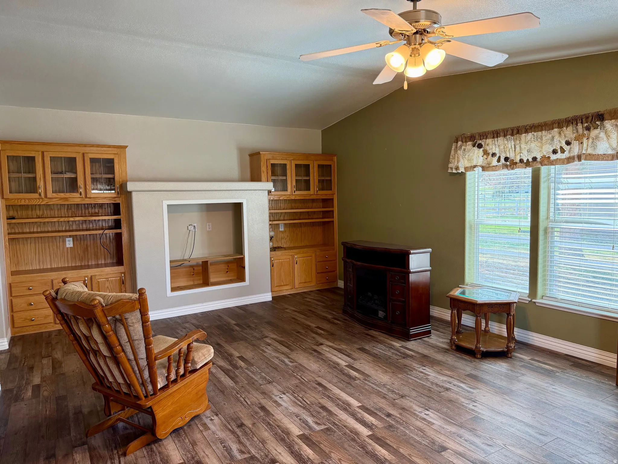 Sitting room featuring ceiling fan, dark wood-style flooring, and lofted ceiling