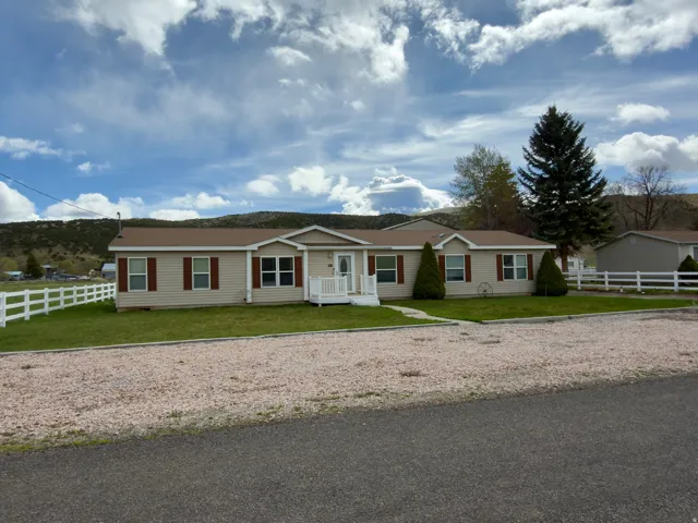 Single story home with gravel driveway