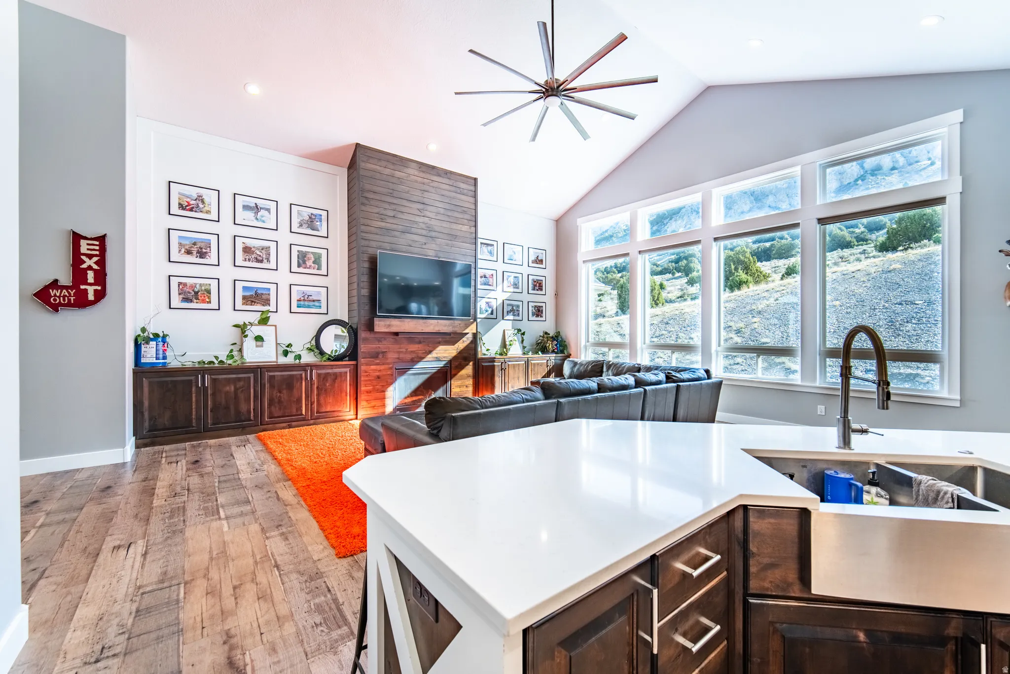 Kitchen featuring ceiling fan, dark wood finish cabinets, wood-style flooring, open floor plan, and recessed lighting