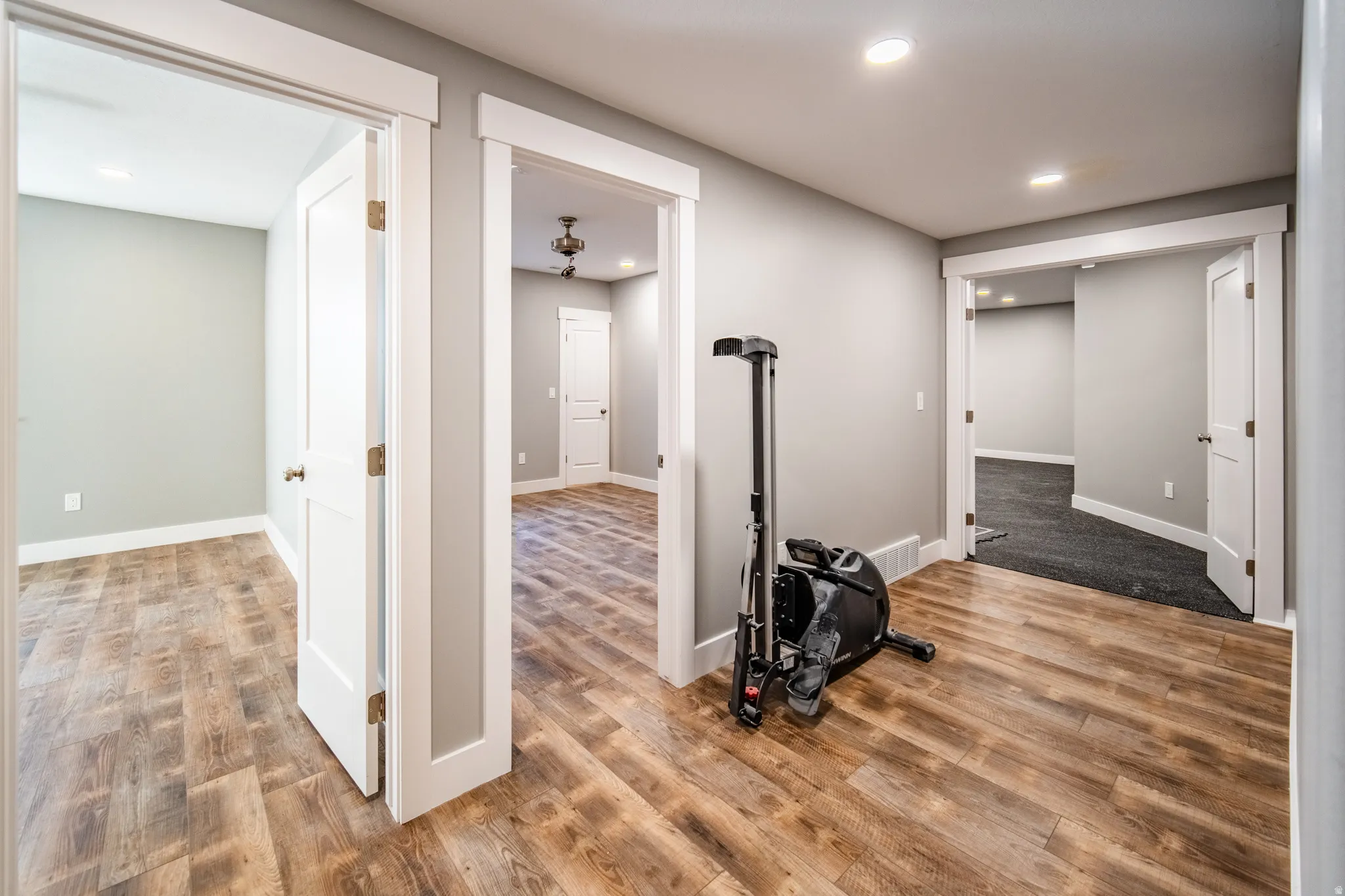 Hallway looking into ensuite bedroom, additional bedroom, and home gym.