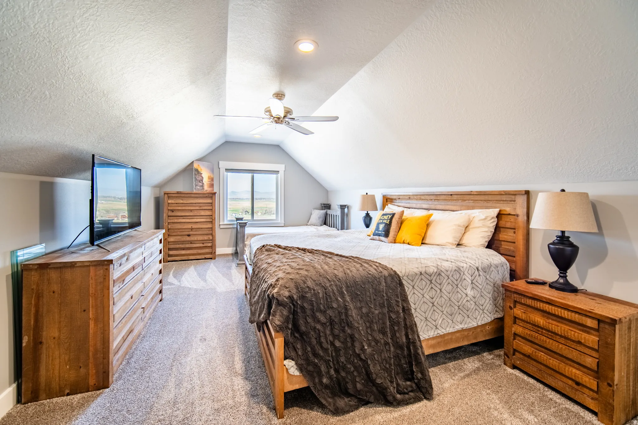 Bedroom featuring a textured ceiling, light carpet, and a ceiling fan
