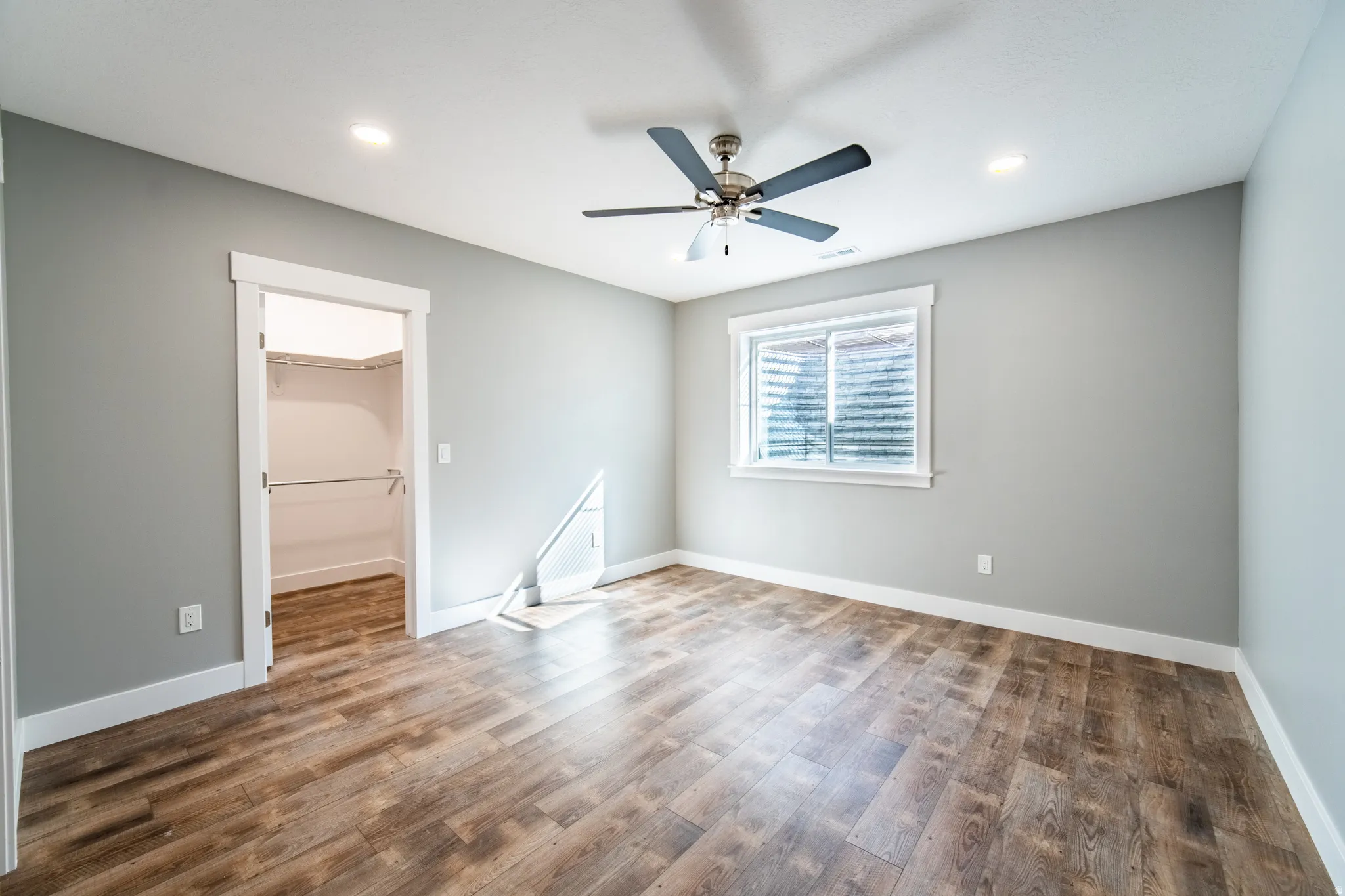 EnSuite bedroom with wood finished floors, ceiling fan, and recessed lighting