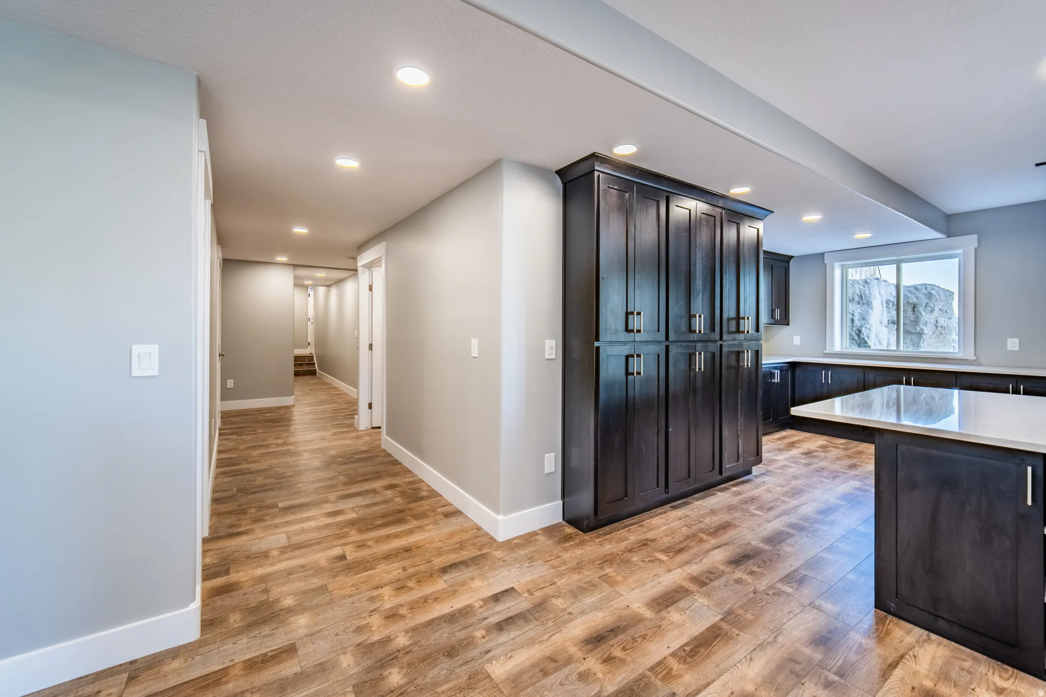 Kitchen featuring wood-style flooring, recessed lighting, and light stone countertops