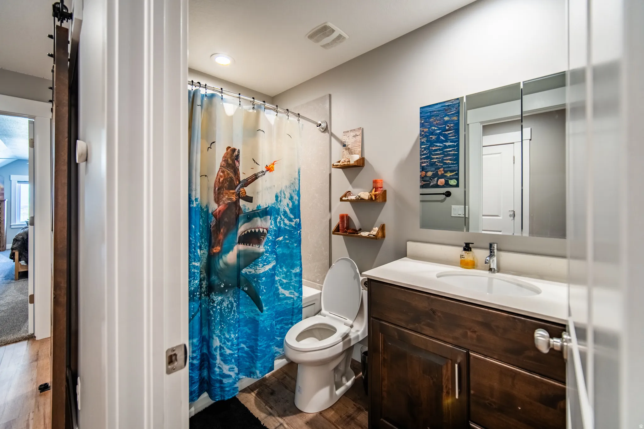 Bathroom with vanity, wood-style floors, and shower / bath combo with shower curtain