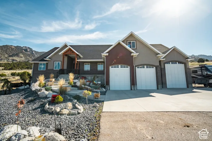 Brick and stone exterior with three-car garage featuring white panel doors